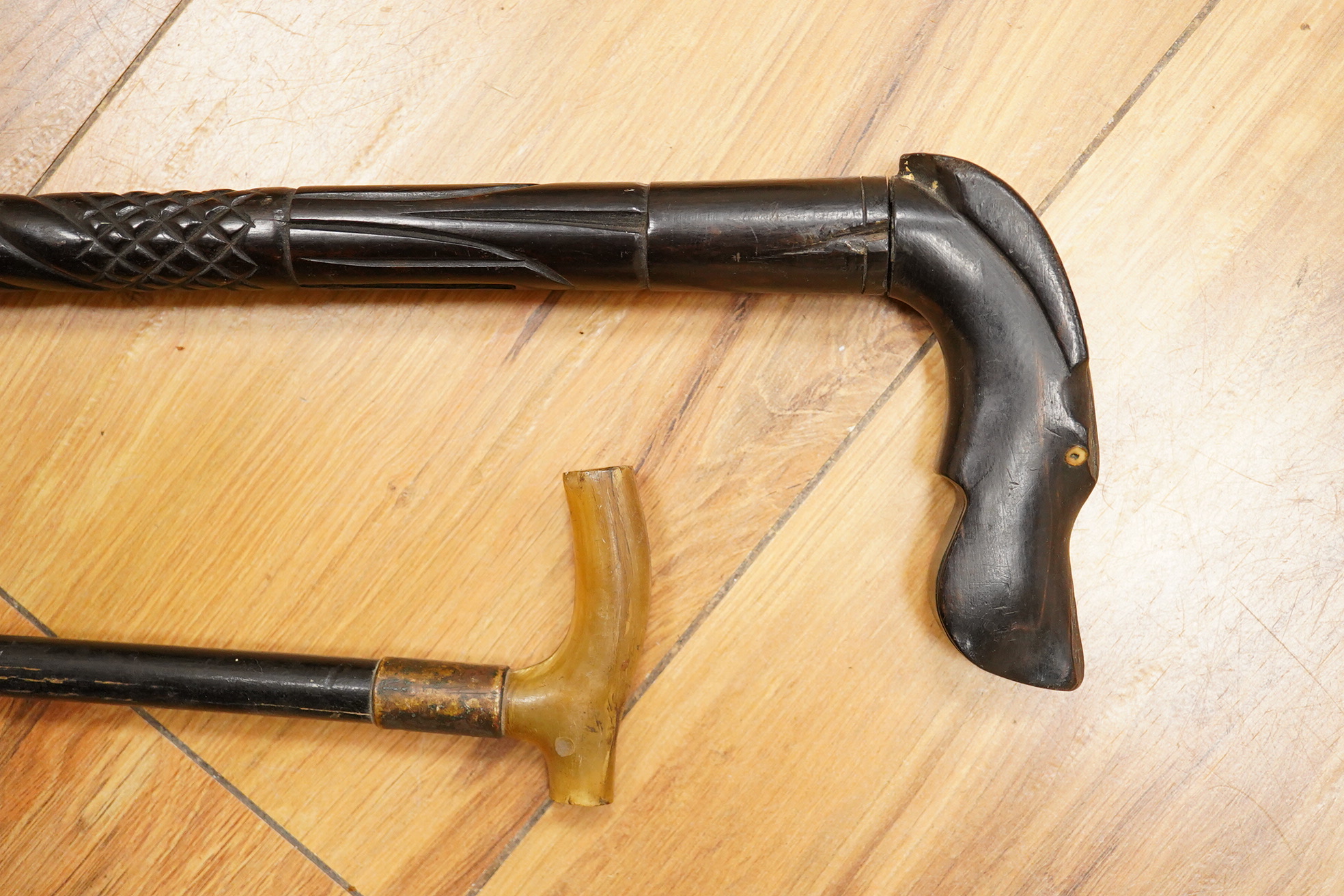 Five walking sticks including horn and a silver topped walking sticks and a carved topped walking stick with concealed chamber containing a metal tube - 93cm long. (5).